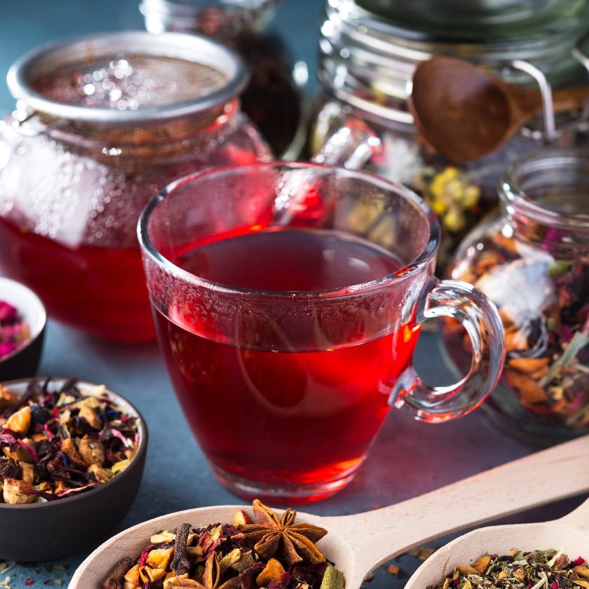 Frischer Früchte- und Kräutertee, trockene Blätter mit Rosenblättern. Sommerliches Erfrischungsgetränk, dunkle Stimmung.