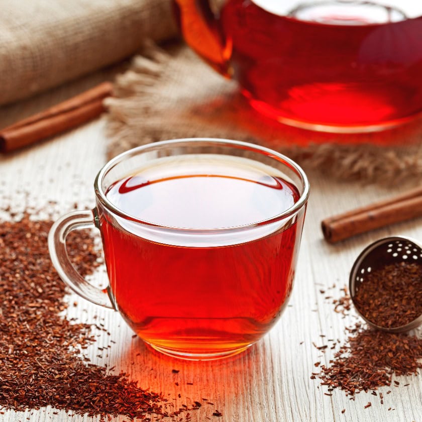 Gesunder traditioneller Rooibos-Kräutertee mit Gewürzen auf einem alten Tisch